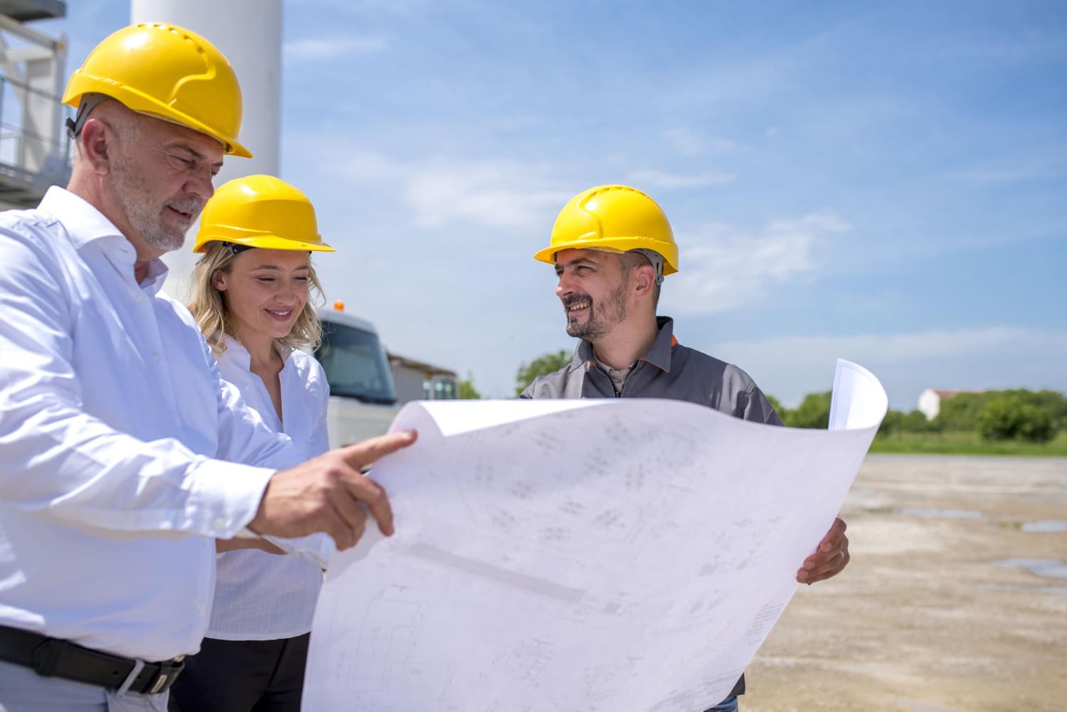 grupo-trabajadores-construccion-mirando-planos-documentos-luz-sol